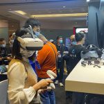 在2021未来商业生态链接大会上，一位女生在试戴VR设备。